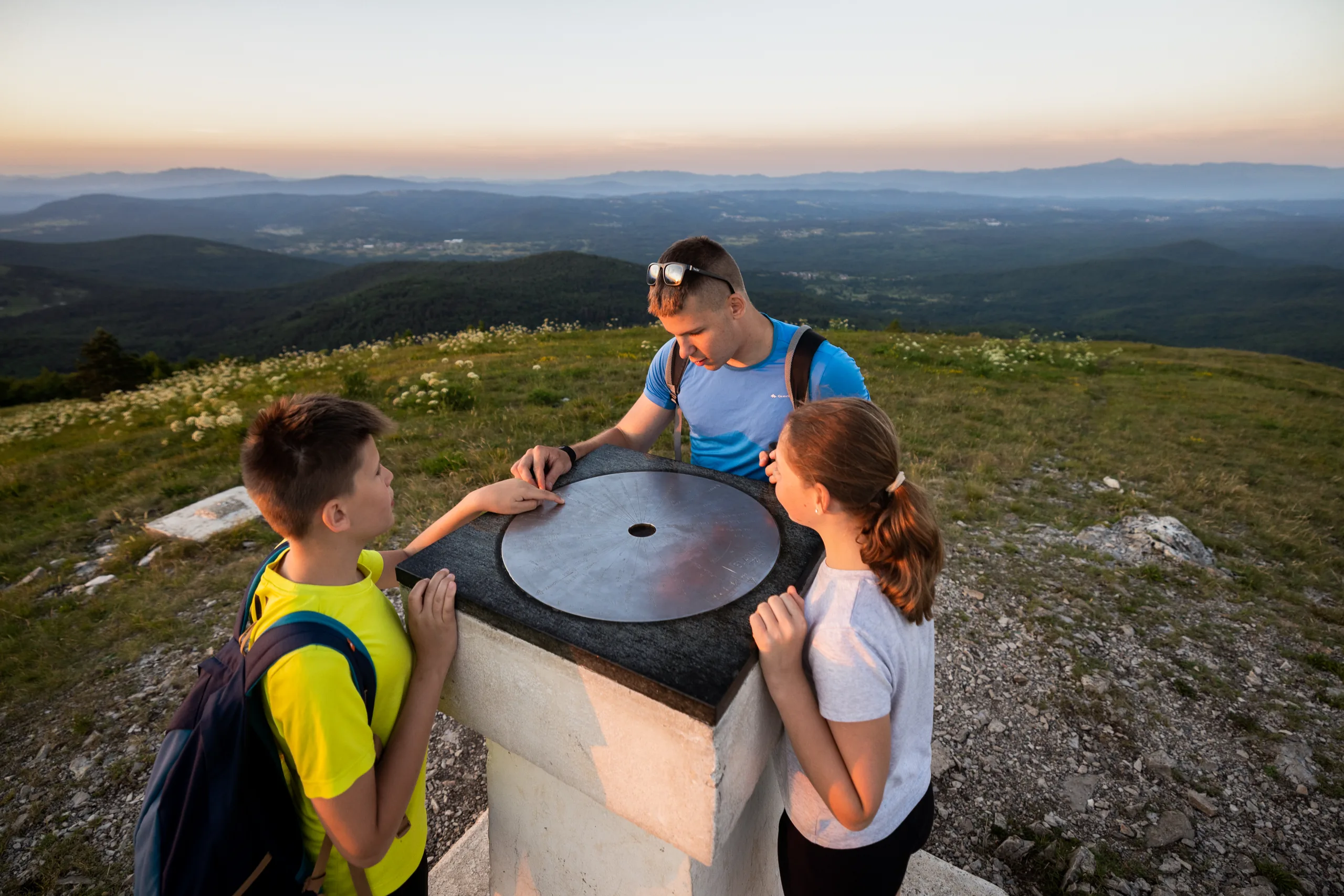 Družina ob panoramski orientacijski plošči na vrhu Slavnika.